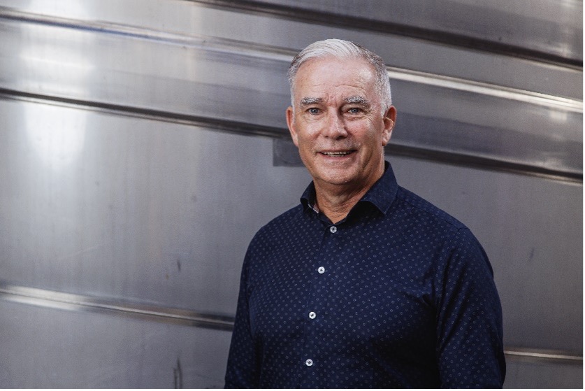 Senior wine industry professional at Links Winery inside the winery production area, surrounded by stainless steel tanks.
